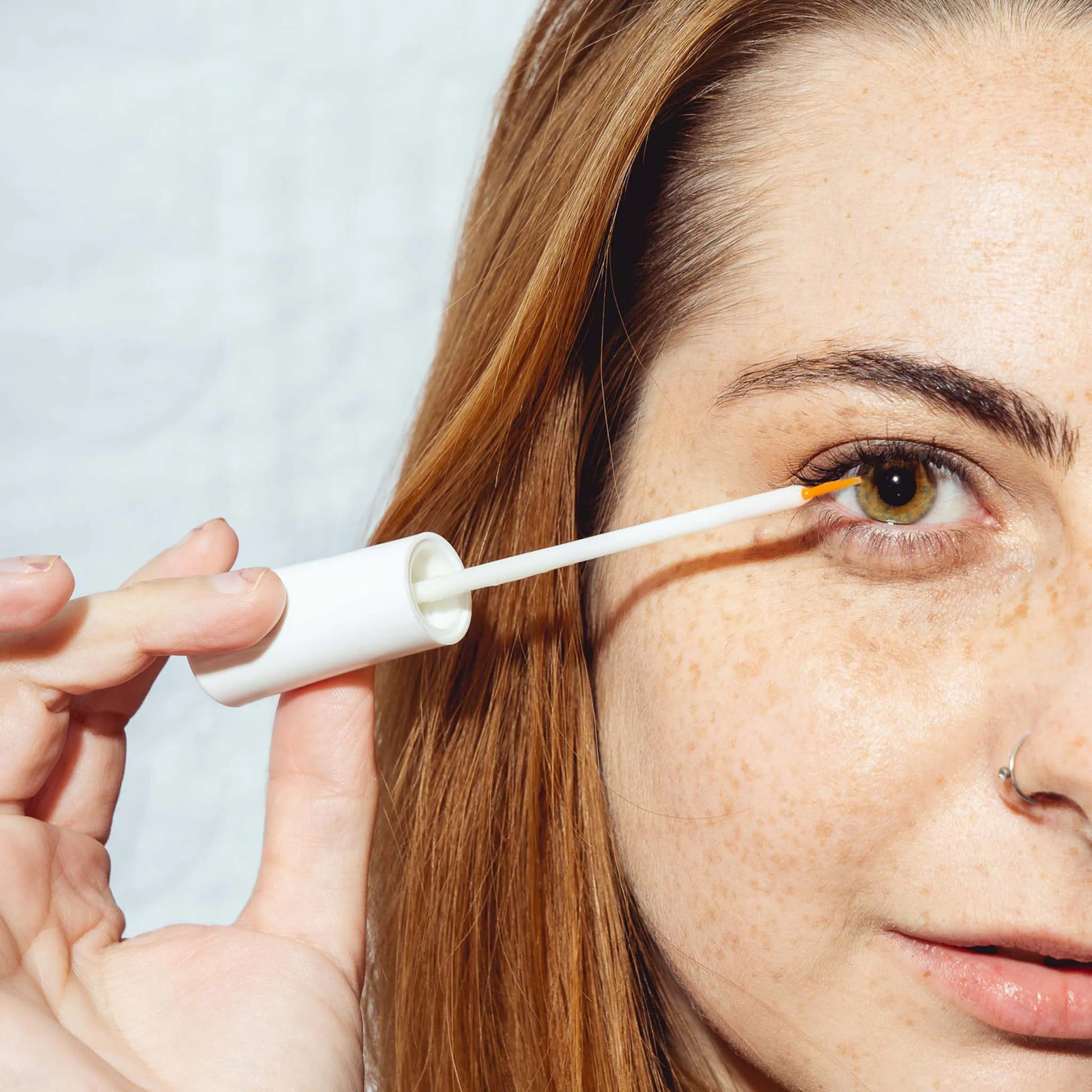een vrouw houdt het serum voor haar oog