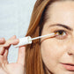 een vrouw houdt het serum voor haar oog