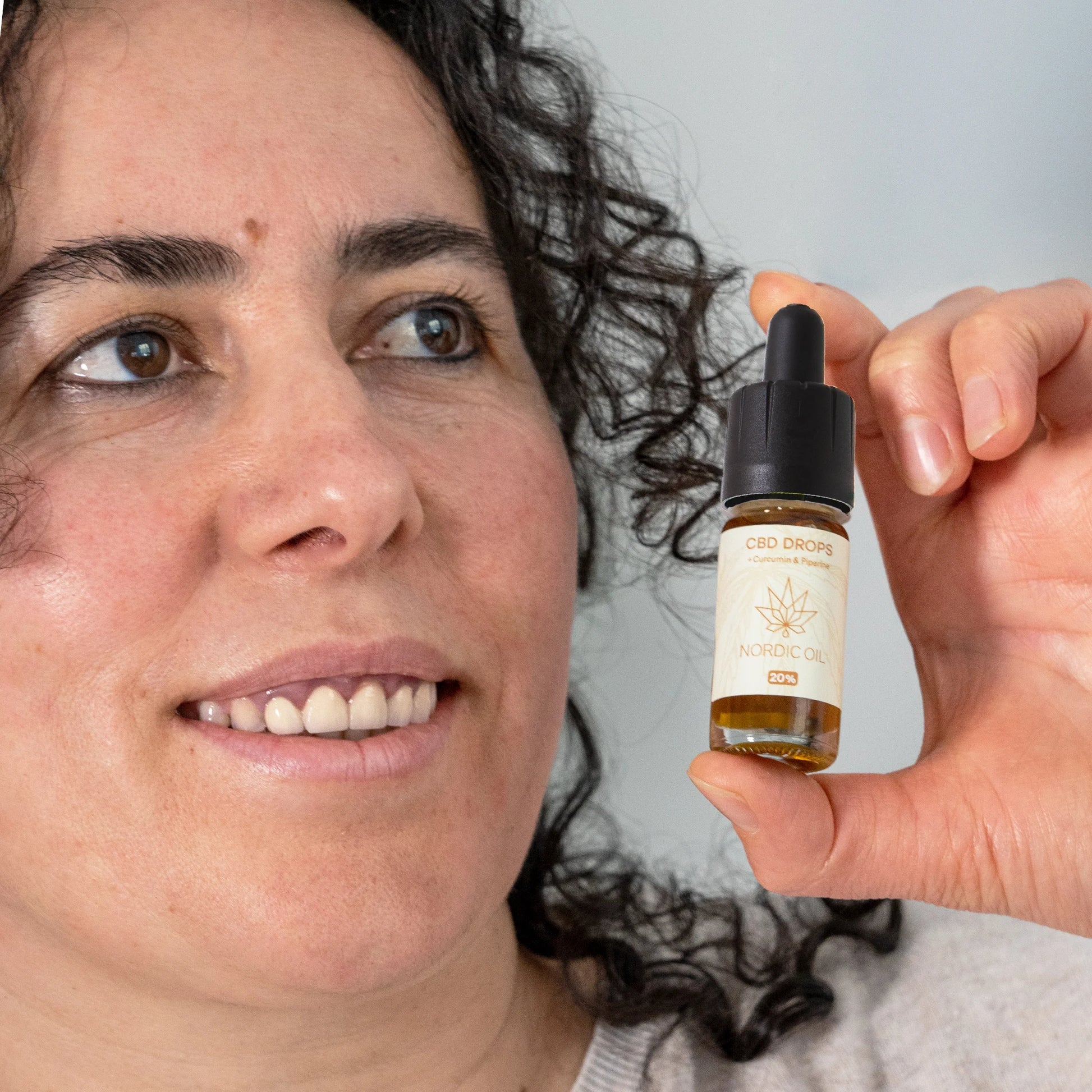 vrouw met nordic oil cbd druppels met curcmin flesje