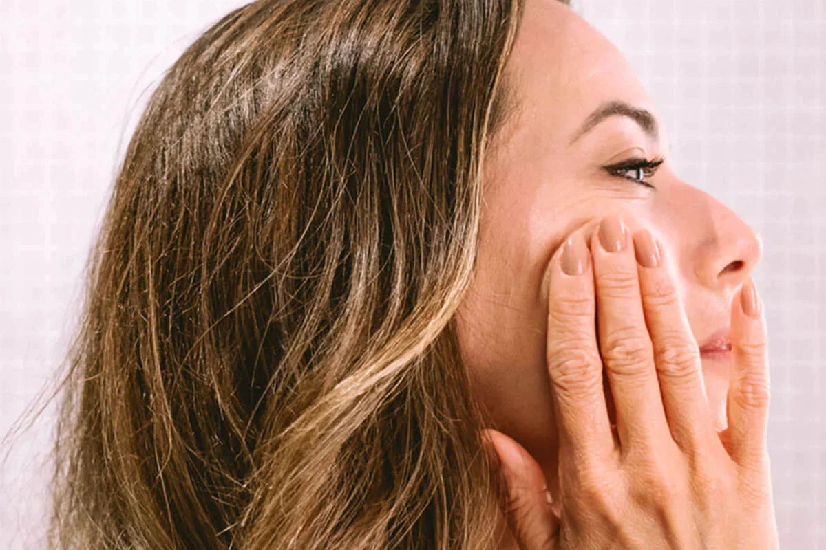 Een vrouw smeert Nordic Cosmetics Anti-Aging Gezichtscrème op haar wang.