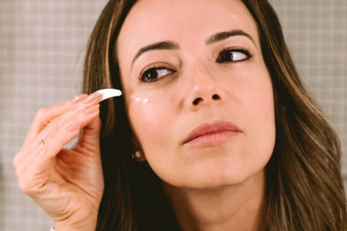 Een vrouw doet Nordic Cosmetics Oogcrème onder haar oog.