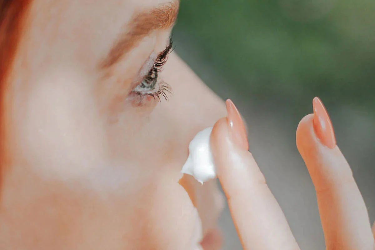 Een vrouw smeert Nordic Cosmetics nachtcrème op haar gezicht.