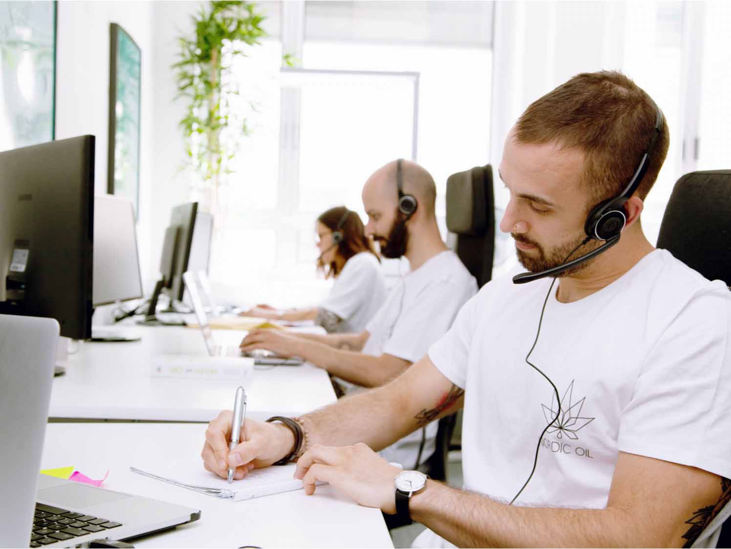 customer service team voor PC met koptelefoon aan het schrijven