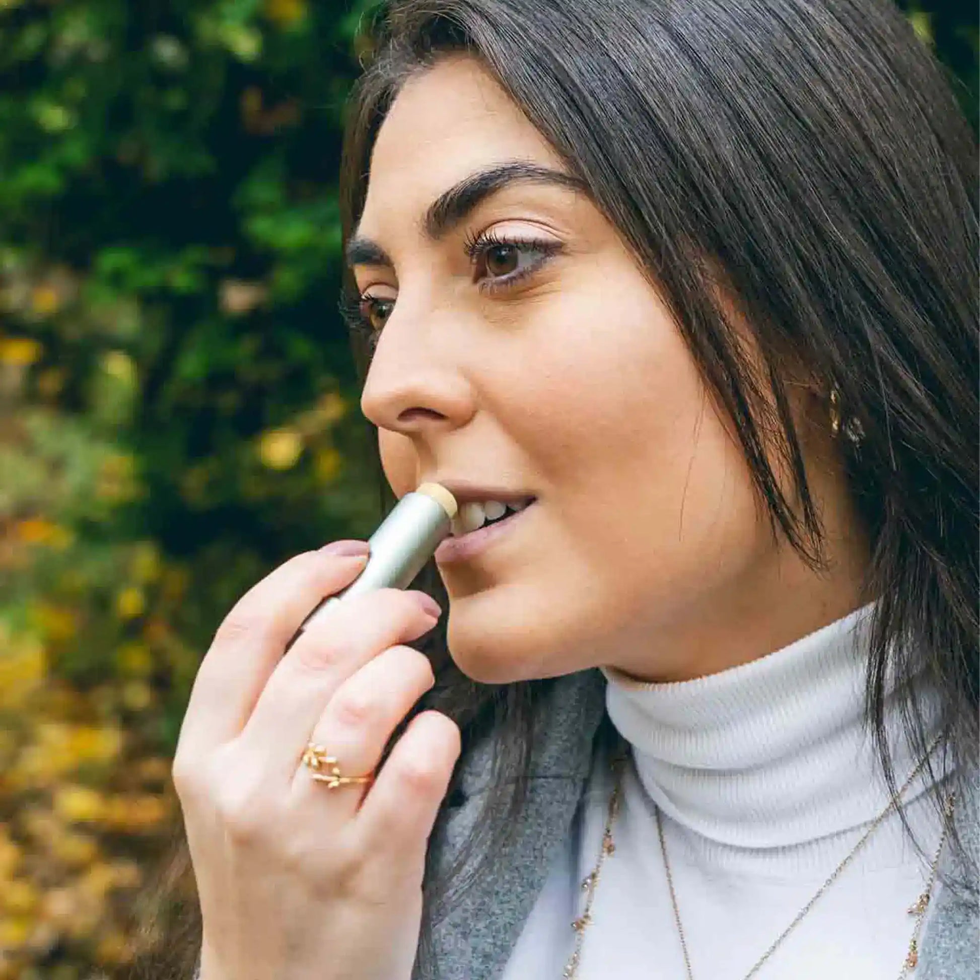 Een vrouw brengt CBD lippenbalsem aan op haar lippen.